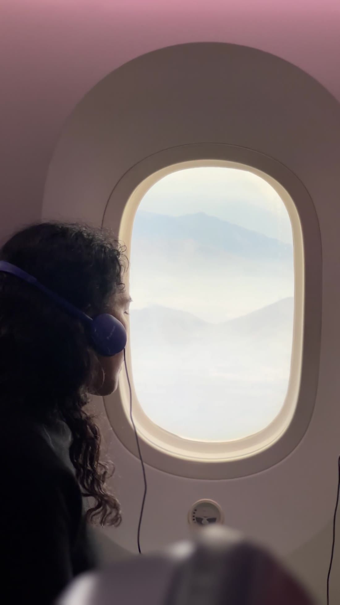 A woman looking out of an airplane window
